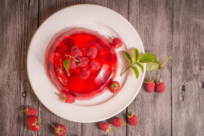 Jelly dessert with strawberries and raspberries on wooden background