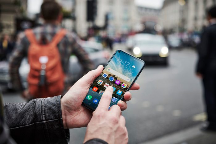 A Man Holding Up An Honor 20 Pro Smartphone