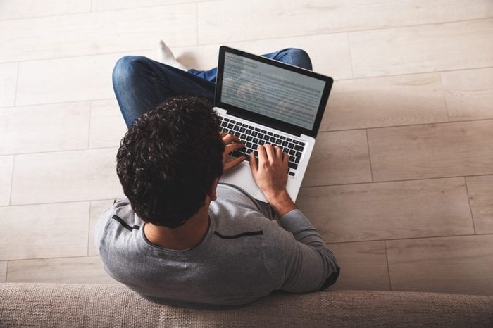 Young man sitting on the floor and using laptop.Online shopping.