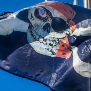 Beautiful pirate flag. Beautiful background and view of the pirate and robber black with bones and skull flag and standard day in summer.