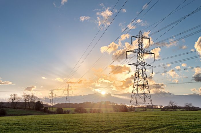Electricity Pylon - UK standard overhead power line transmission tower at sunset.