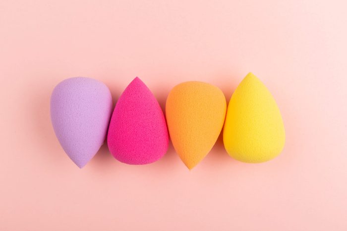 Colorful beauty sponges on pink background. Makeup tool for applying and blending products such as foundation, concealer. Horizontal shot. Copy space for text.