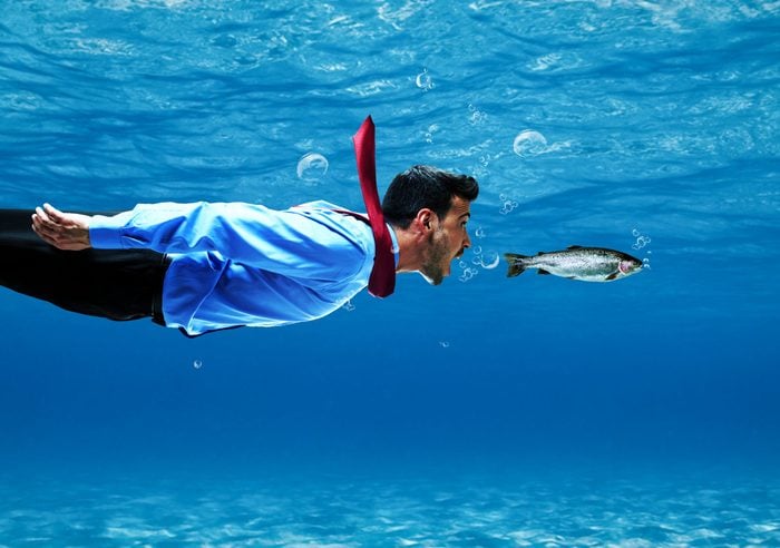 Funny businessman swimming underwater