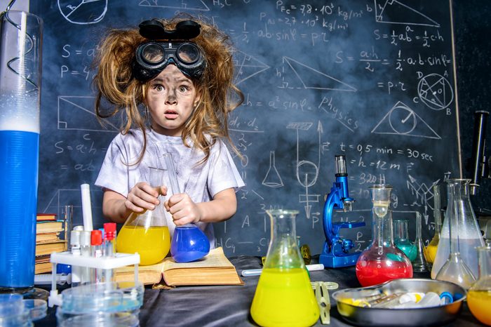 Funny little girl doing experiments in the laboratory. Explosion in the laboratory. Science and education.
