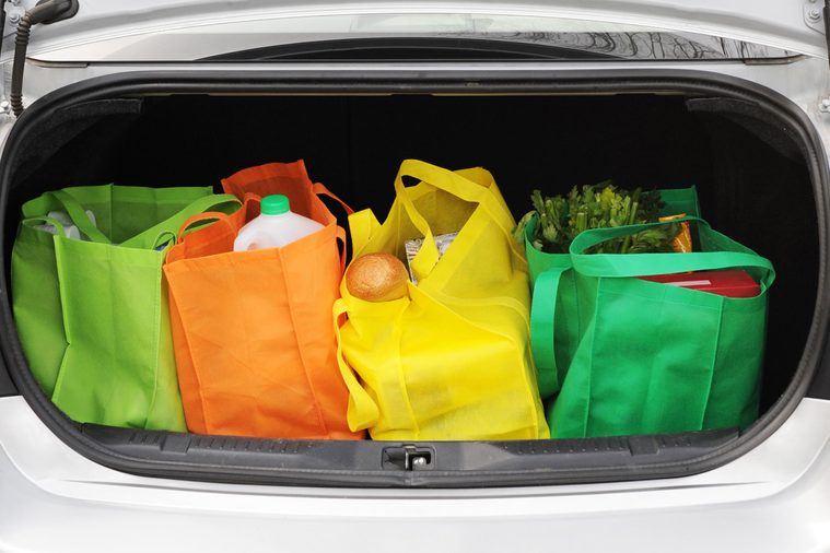 reusable bags with groceries in a car trunk