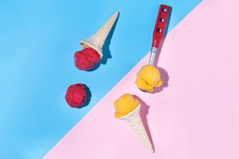 scoops of sorbet and sherbet on blue and pink background with ice cream cones and dessert scoop