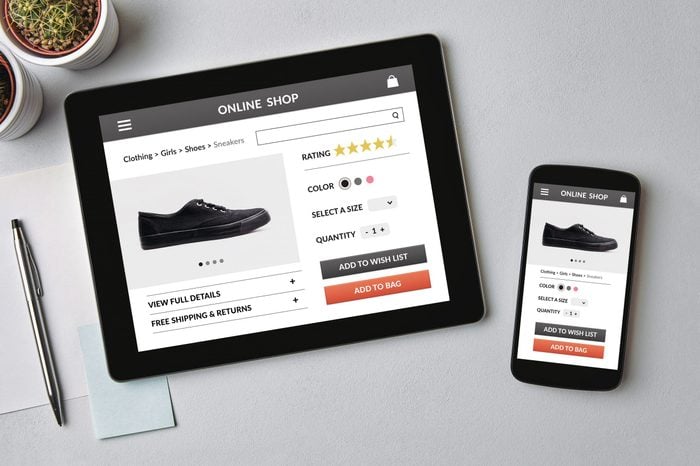 Online shop concept on tablet and smartphone screen over gray table. All screen content is designed by me. Flat lay