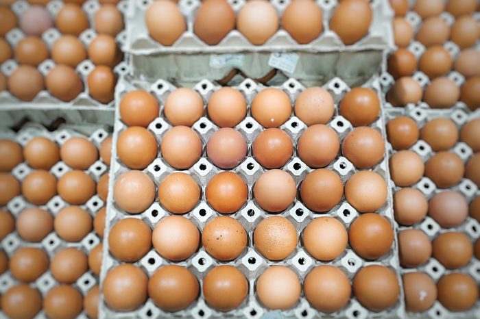 Dozens of Eggs in cartons stacked at the supermarket. Eggs are a very good source of inexpensive, high quality protein. 