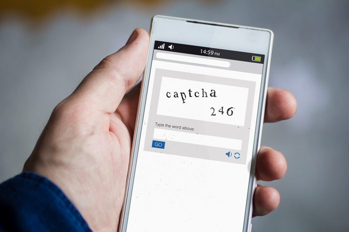 man hand holding captcha smartphone. All screen graphics are made up.