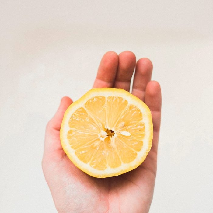 hand holding half lemon