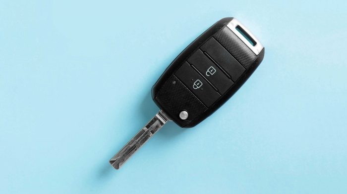 Car key on color background, top view with space for text