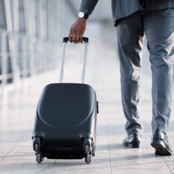 Businessman At Airport Moving To Terminal Gate For Business Trip, Back View