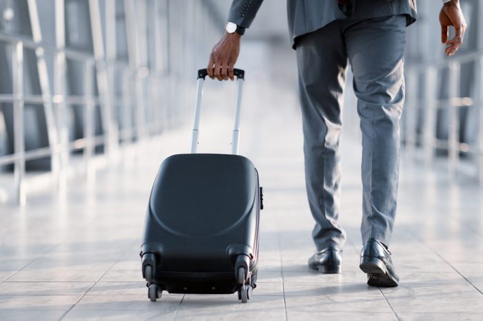 Businessman At Airport Moving To Terminal Gate For Business Trip, Back View