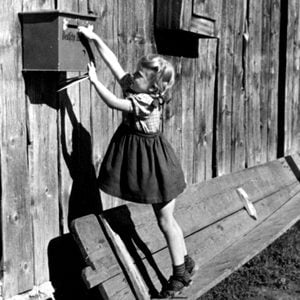 little girl reaching for mailbox