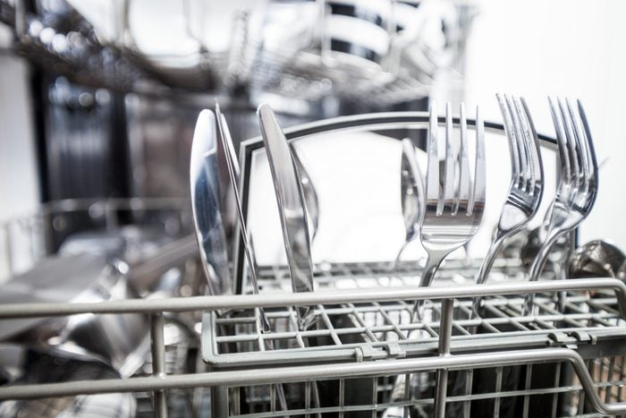 Clean dishes in dishwasher machine after washing, close up