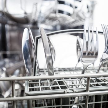 Clean dishes in dishwasher machine after washing, close up