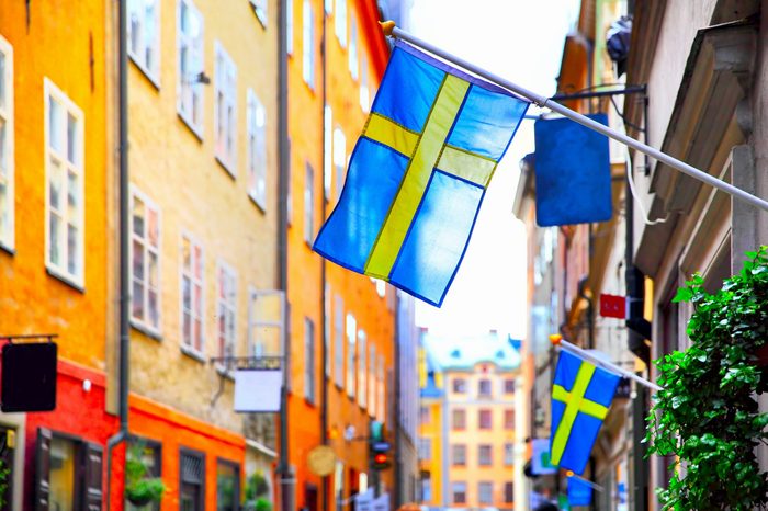 Old street in Stockholm with swedish flags, Sweden. Shallow DOF, focus on the first flag