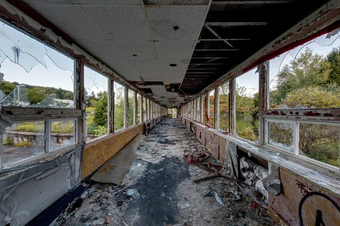 A view of a long and exposed hallway at the decrypt and abandoned Pines Resort in the Catskill Mountains of New York.