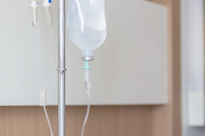 Saline solution drip set and bottle on a pole for patient and infusion pump in hospital