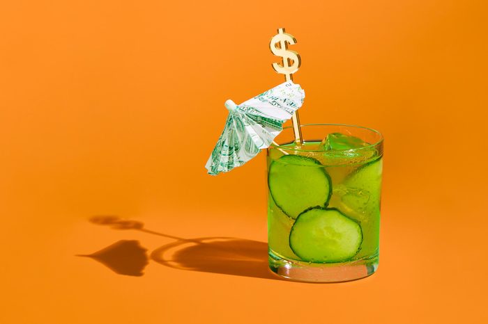 Cocktail with money umbrella and stir stick concept photograph by sarah anne ward
