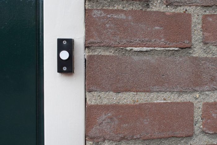Black and white doorbell at the door of a living house