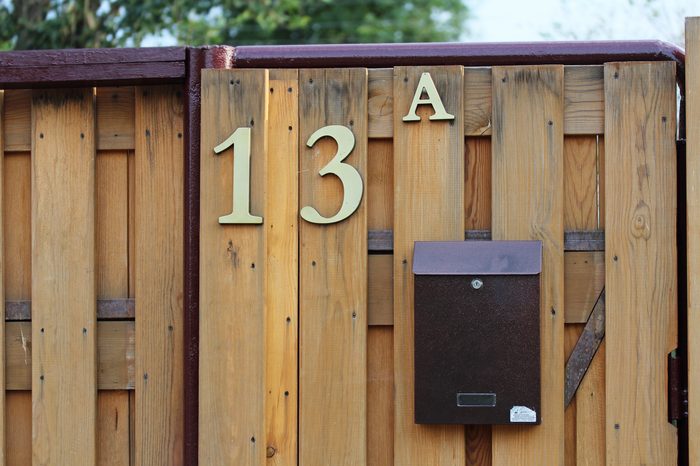 House number 13A on a wooden fence with a mailbox