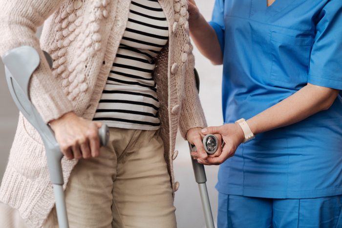 Admirable caring nurse helping feeble lady