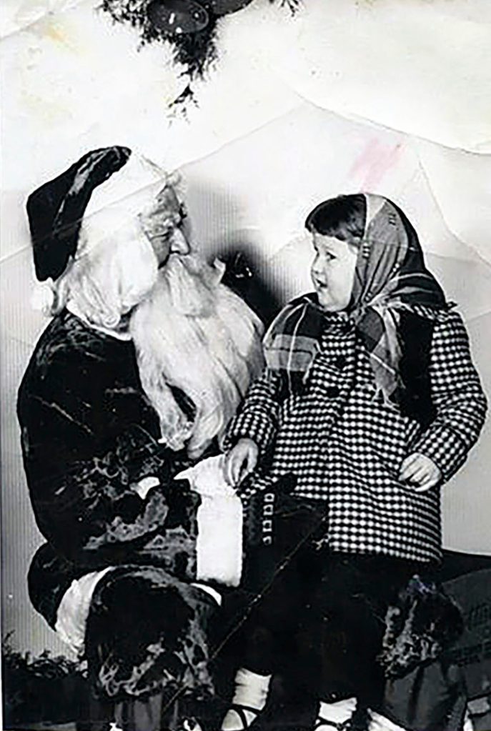little girl sitting on santa's lap - plaid coat