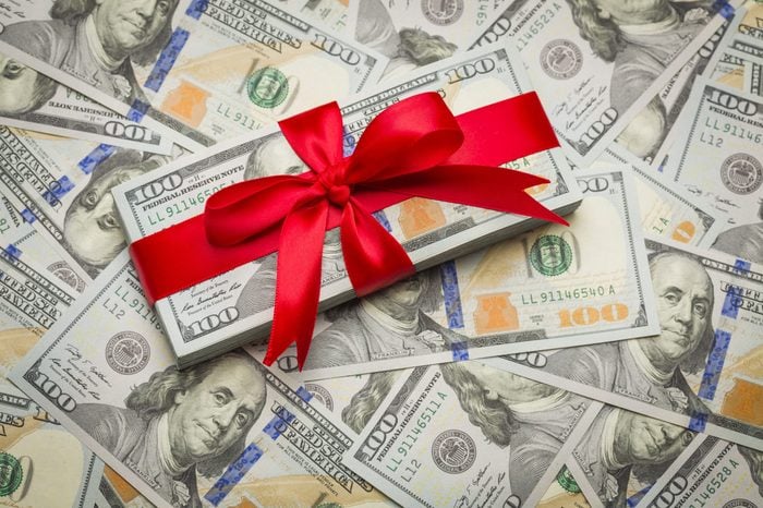 Stack of Newly Designed U.S. One Hundred Dollar Bills Gift Wrapped in Red Bow.