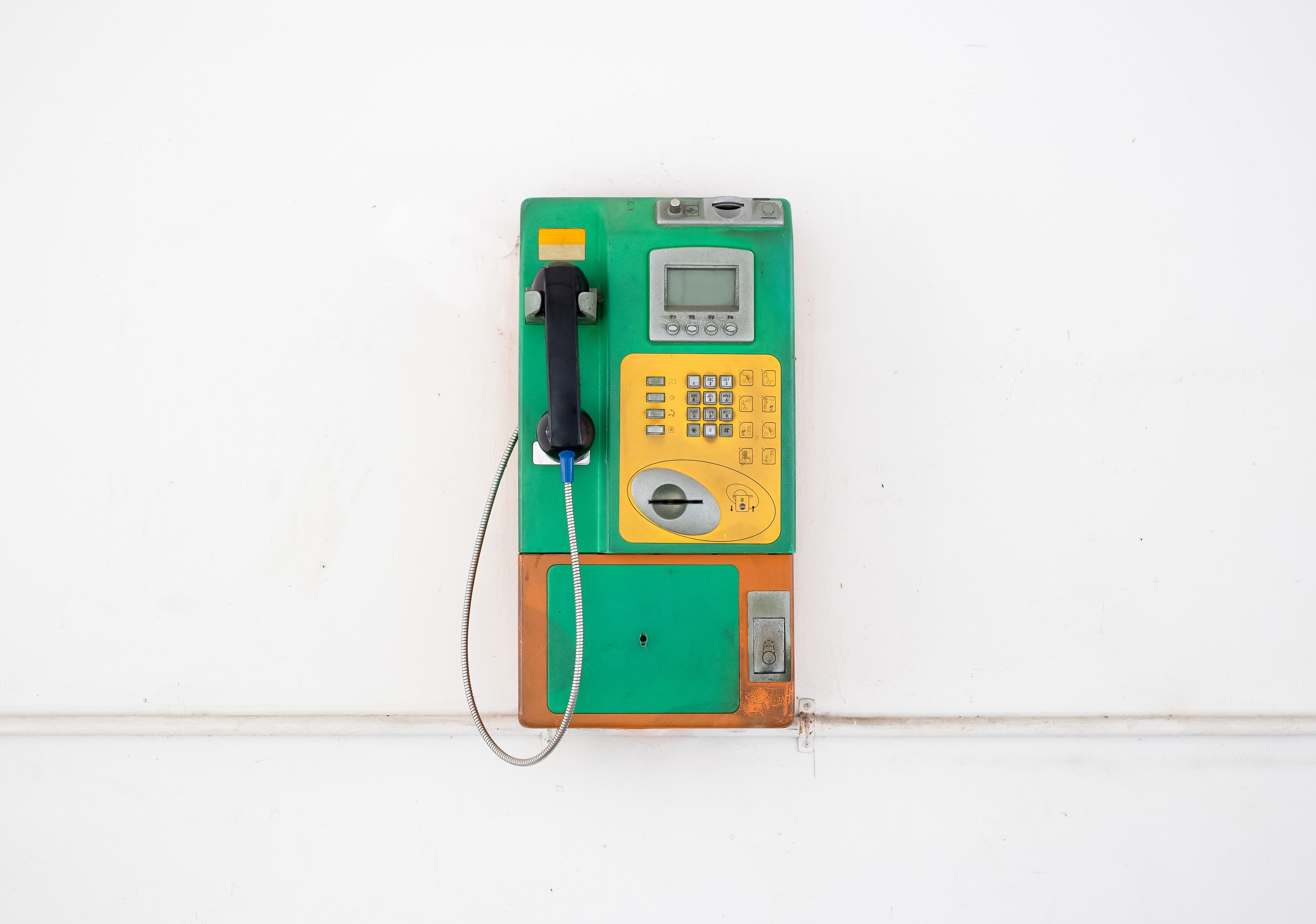Coin-operated public payphone and white background