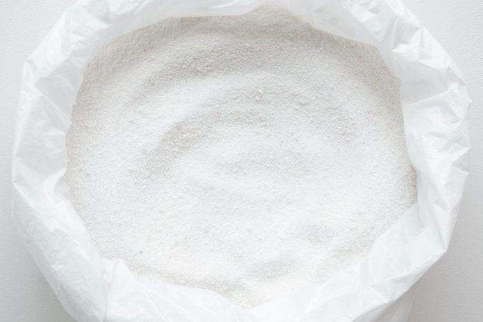 White powder in plastic pack. Detergent for regular clothes washing. Top view. Closeup.