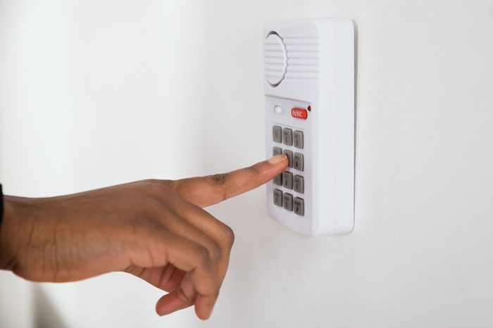 Close-up Of African Businesswoman Hand Pressing Button On Door Security System
