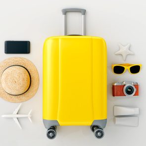 Flat lay yellow suitcase with traveler accessories on white bright background. travel concept