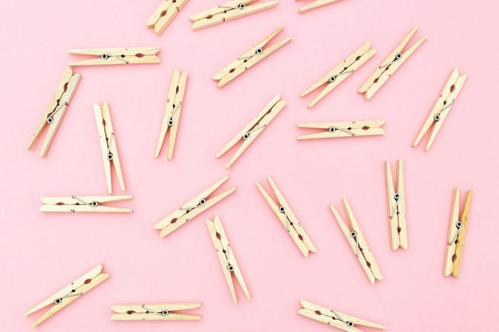 Wooden clothes pegs on pink background. Zero waste