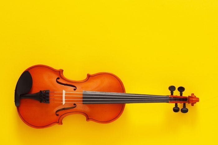 Classical music concert poster with orange color violin on yellow background with copy space for your text
