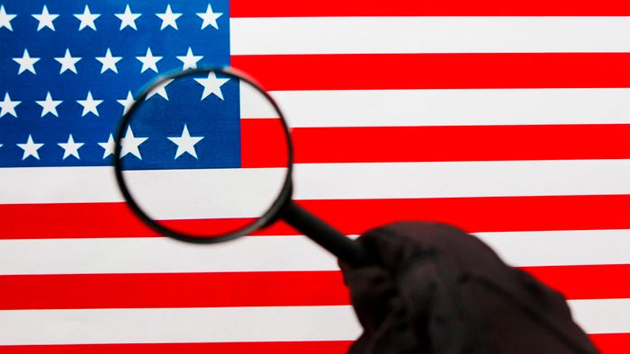 US flag looking through a magnifying glass. Study of the history and culture of the country of the United States. The concept of studying geography, English and customs.