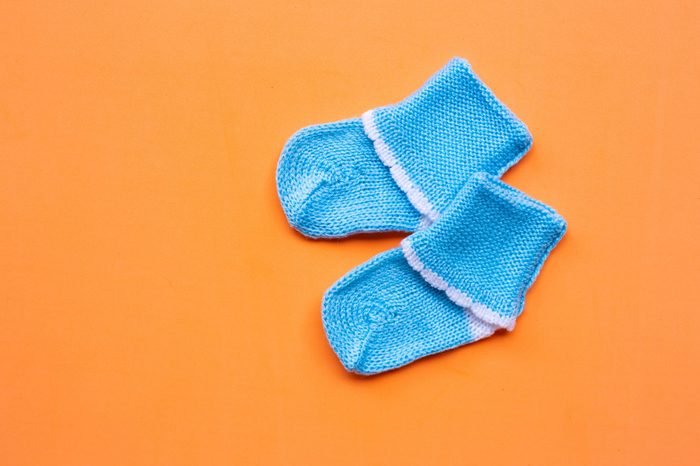Baby socks on orange background. Top view