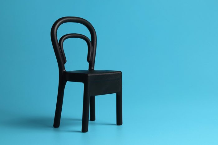 Close up a mini black chair isolated on blue background. Chair person concept.