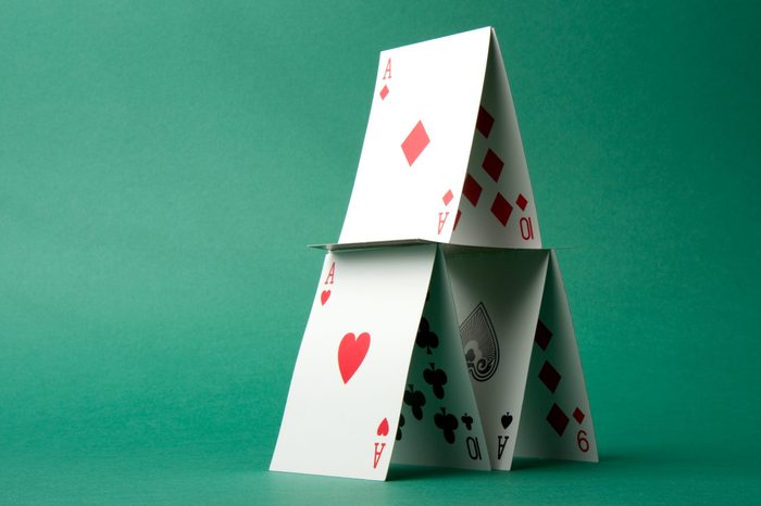 A house of cards on a green background.