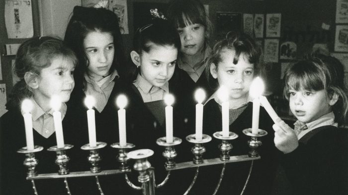 school girls lighting the menorah