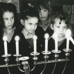 school girls lighting the menorah