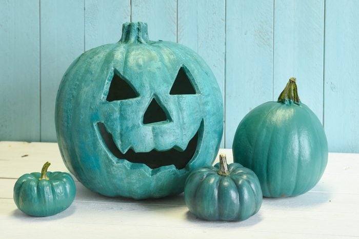 Teal pumpkins in a Halloween still life indicating that both allergy safe non food treats as well as candies are available to trick and treaters. 