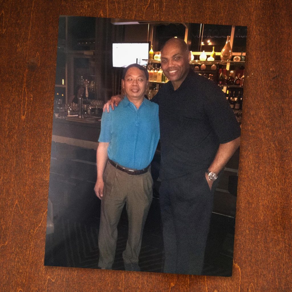 Charles Barkley poses with Lin Wang at the bar where they met.