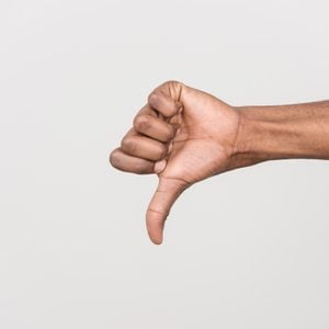 Thumb down hand signs isolated on white. black man hand gesturing with hand on white