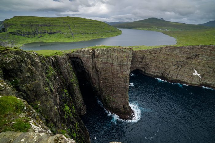 Traelanipa cliff is seen rising over the ocean next to lake Sorvagsvatn in the Faroe Islands
