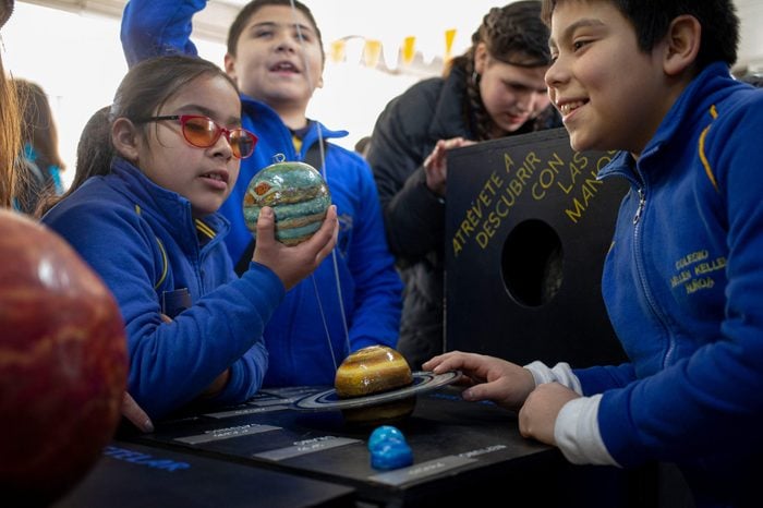 Blind school children take part in a sensorial experience with tools created by NASA and Edinburgh University to experience an eclipse, during an event in the Helen Keller school in Santiago, Chile. 25 June 2019