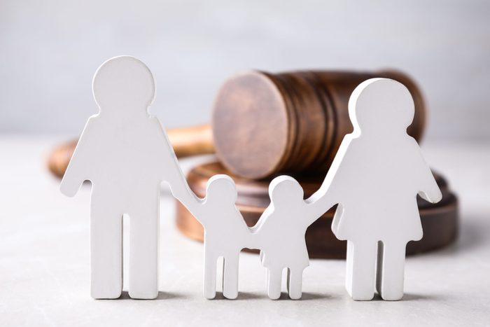 Figure in shape of people and wooden gavel on light table. Family law concept