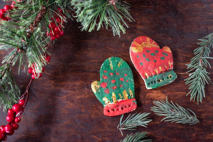 hand painted Christmas mitten salt dough ornaments on festive wood table