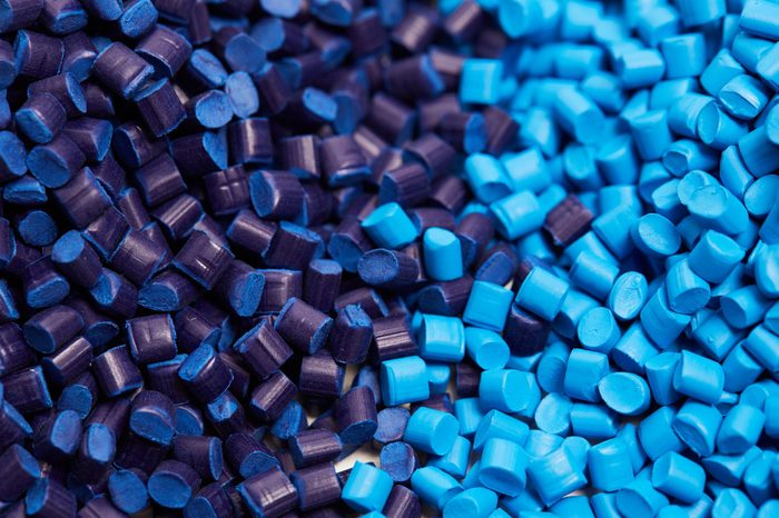 Close up of a two stacks of blue plastic polypropylene granules on a table