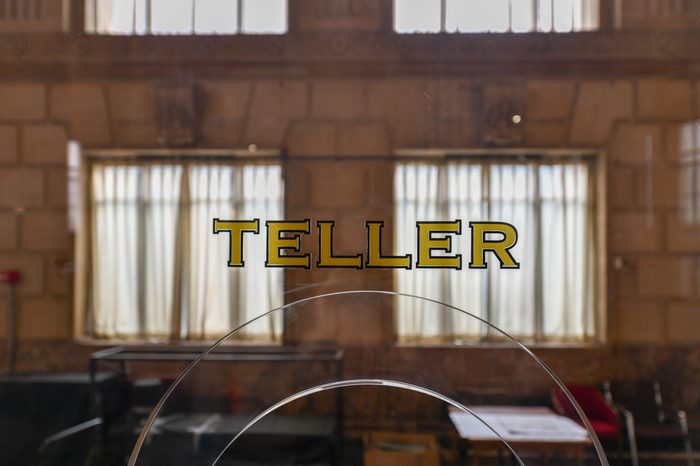 Old fashioned bank teller window sign in a classically styled building.